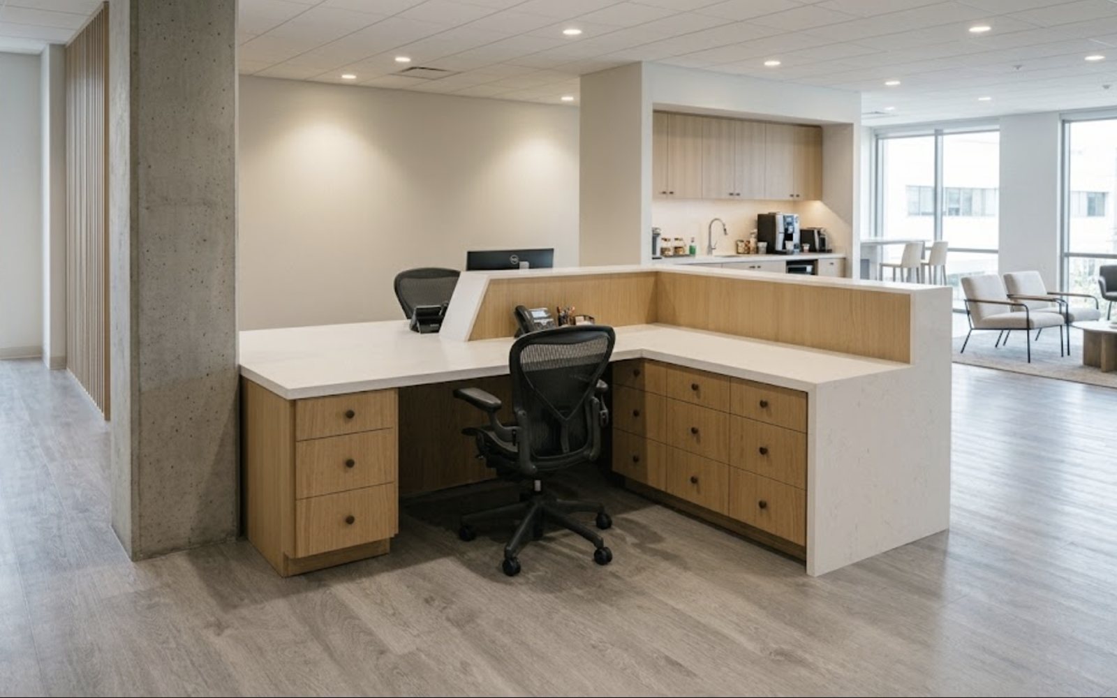 Finished L-shaped reception desk with oak drawer banks, a raised oak transaction panel and a white quartz waterfall end